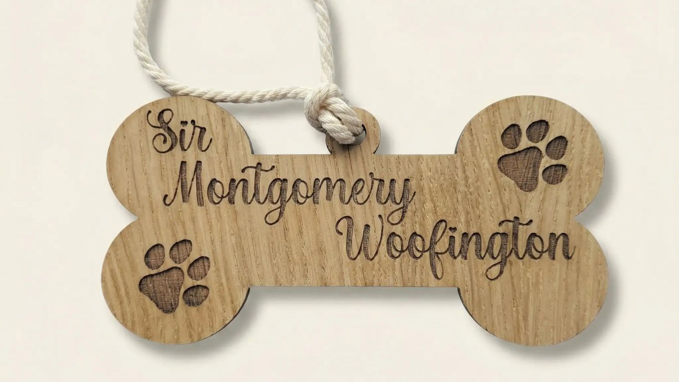 Wooden bone-shaped tag with paw prints and name for a pet.