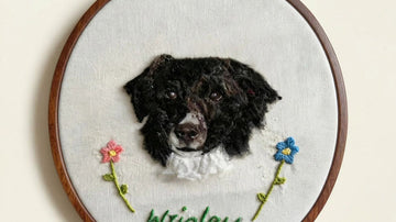 Embroidery of a dog's face with flowers and name 'Wrigley'.