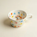 Dog figurine sitting inside floral ceramic mug