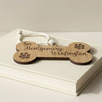 Wooden dog bone plaque resting on books