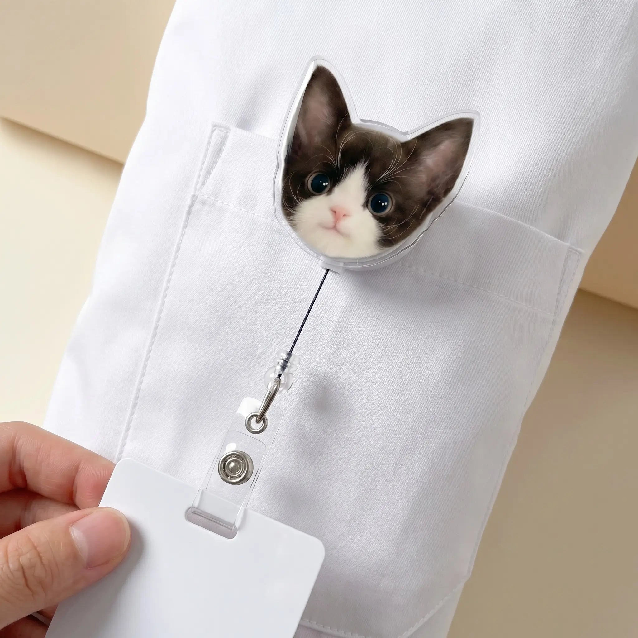 Cat badge reel clipped to white pocket
